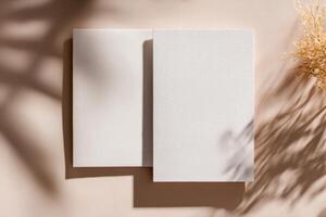 Two blank white sheets of paper on a tan background photo
