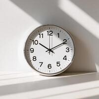 A clock is shown on a white surface photo