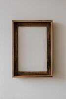 A wooden frame on a wall with a blank white background photo