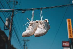 White sneakers hanging on a wire photo