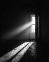 A black and white photo of a room with sunlight streaming through the door