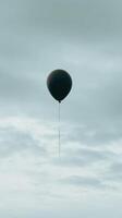 A black balloon floating in the sky photo