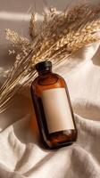 A bottle of essential oil and a stalk of wheat on a linen cloth photo
