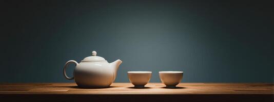 Tea pot and two cups on a wooden table photo