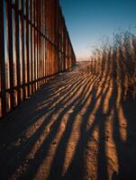 The border fence in the desert with shadows photo