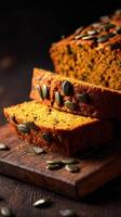 Pumpkin bread with pumpkin seeds on a wooden cutting board photo