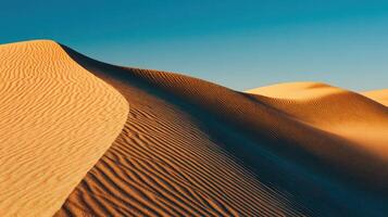 A desert with sand dunes and a blue sky photo