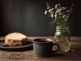 A cup of coffee and bread on a table next to a vase of flowers photo
