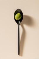 Olive on a spoon photo