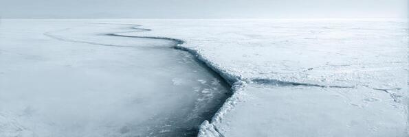 A long crack in the ice on a frozen lake photo