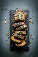 Sliced bread with pumpkin seeds and nuts on a slate board photo