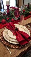 Elegant christmas dinner table setting with red accents and pinecone decor photo