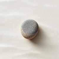 A stone on a white surface with a gray spot photo