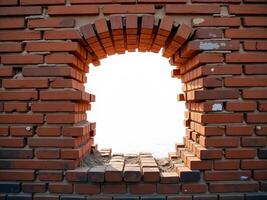 A red brick wall with a hole in the middle, the hole is oval shaped, the background is white photo