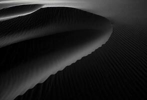 Sand dunes create intricate patterns and shadows in a desert landscape during twilight photo
