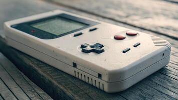 A close-up shot of a classic, handheld Game Boy console on a wooden surface shows detail. photo