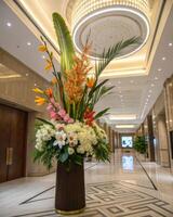 An elegant floral arrangement welcomes guests in a luxurious hotel lobby with exquisite design and lighting. photo