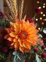 An exquisite orange dahlia and burgundy flowers display with wheat and soft bokeh. photo