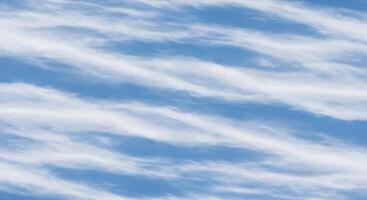 A blue sky with clouds and a plane flying in it photo