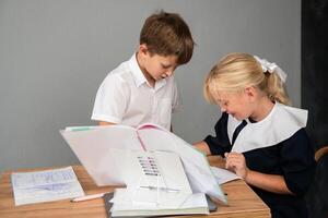 Children School Classroom Study Desk - Two kids in school uniform study together at a desk. photo