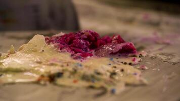 An ice cream vendor chops cream and berries with spatulas to make ice cream video