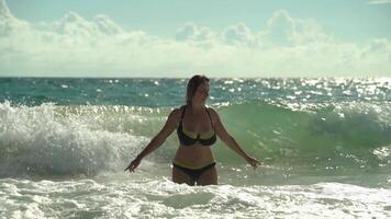 Beautiful girl among big waves on a sunny summer day in the open sea video