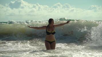 Sea waves hit a girl in the open sea in slow motion video