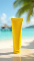 A yellow tube of sunscreen on a table in front of a beach photo