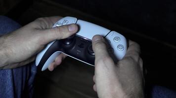 Man hand holding game joystick, gamer pressing buttons on gamepad. Close-up of fingers on controller, gaming session, game passion video