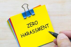 Zero harassment text on yellow sticky notes representing a no-tolerance policy towards abuse and misconduct. photo