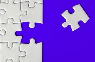 Connecting missing white jigsaw puzzle symbolizes partnership and unity on blue background photo