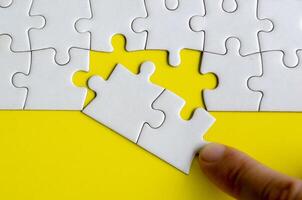 Hand placing missing jigsaw puzzles. A simple yet powerful concept of puzzle parts representing solutions unity and purposeful connection photo