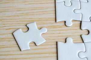 Top view of missing jigsaw puzzle on wooden background photo