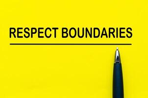 Respect boundaries text on yellow lines with pen representing awareness of personal space and consent photo