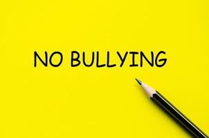 No bullying text on yellow pad with pen representing efforts to foster a supportive and respectful culture photo