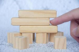 Hand pointing empty wooden blocks with customizable space for text. photo