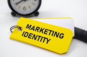 Marketing Identity text in bold black font on yellow sticky note. photo