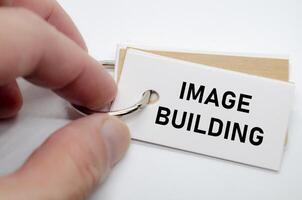 Image building slogan on white note suggesting reputation creation and consistent branding practices. photo
