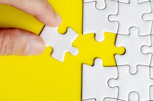 Hand connecting a puzzle part in perfect harmony demonstrating logic clarity and teamwork in design photo