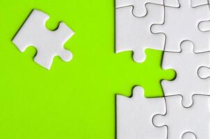 Connecting missing white jigsaw puzzle symbolizes partnership and unity on green background photo