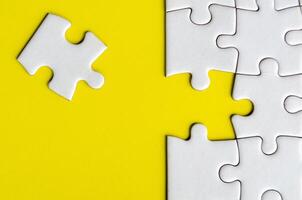 Connecting missing white jigsaw puzzle symbolizes partnership and unity on yellow background photo