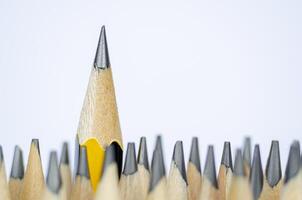 Close up view of pencil standing out from the rest of the pencils representing Courage or Leadership. Courage of leadership concept photo