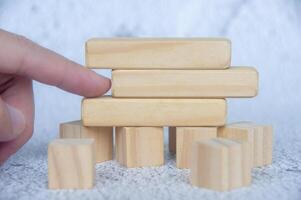 Hand pointing empty wooden blocks with customizable space for text photo