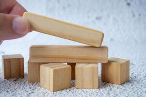 Close up of hand putting a wooden blocks with customizable space for text photo