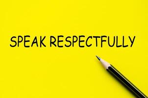 Speak respectfully text on yellow pad with pen representing the value of mindful and dignified communication photo