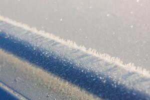 A detailed close up of freshly fallen snow resting on a blue surface photo