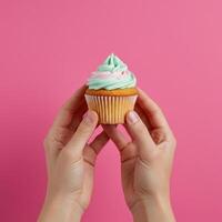 Delicate confectionery presentation a confection with pastel frosting held gently photo