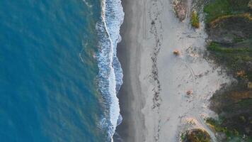 Stormy Ocean Waves Crash Resiliently on Sandy Shores Overhead Aerial video