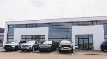Modern Car Dealership Building Showing New Suvs Parked Outside photo