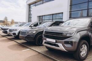New cars parked in front of dealership building waiting for customers photo